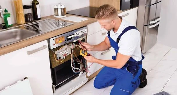 Repair professional testing dishwasher wiring beneath a kitchen counter