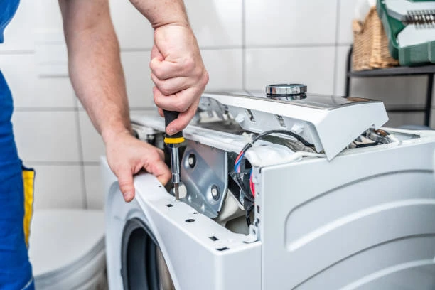 Close-up of a technician inspecting internal washing machine components